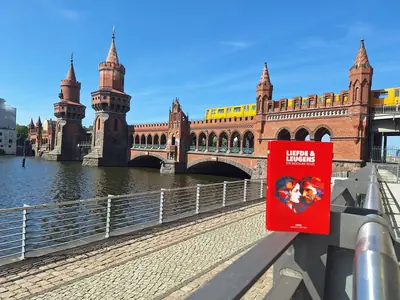 Het boek op een reling met de Oberbaumbr&uuml;cke en een gele metro erachter.